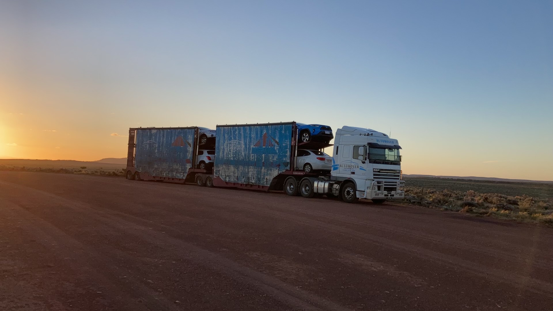 Auto Mover Scania Truck Transporting Multiple Vehicles at Sunset