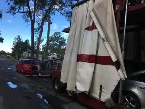 Auto Mover Red Sedan Secured on Transport Trailer