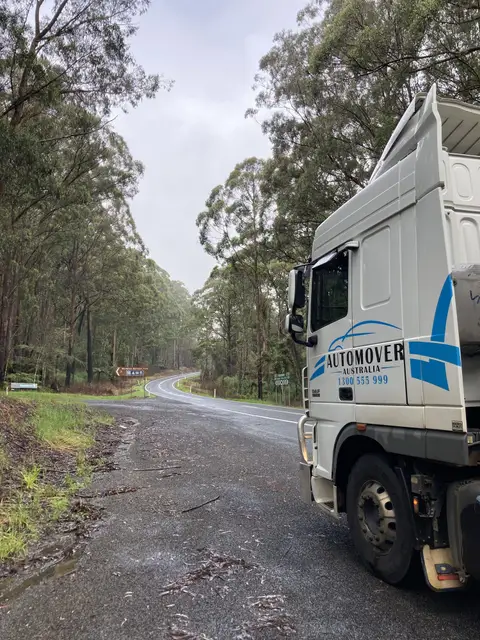 Auto Mover Truck Navigating Scenic Forested Highway Route
