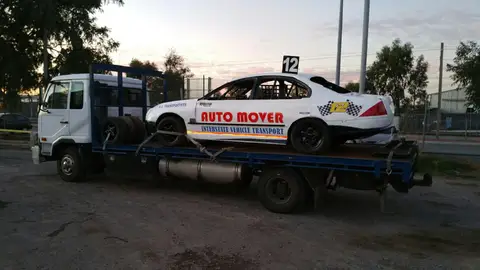 Auto Mover White Sedan on Interstate Transport Truck