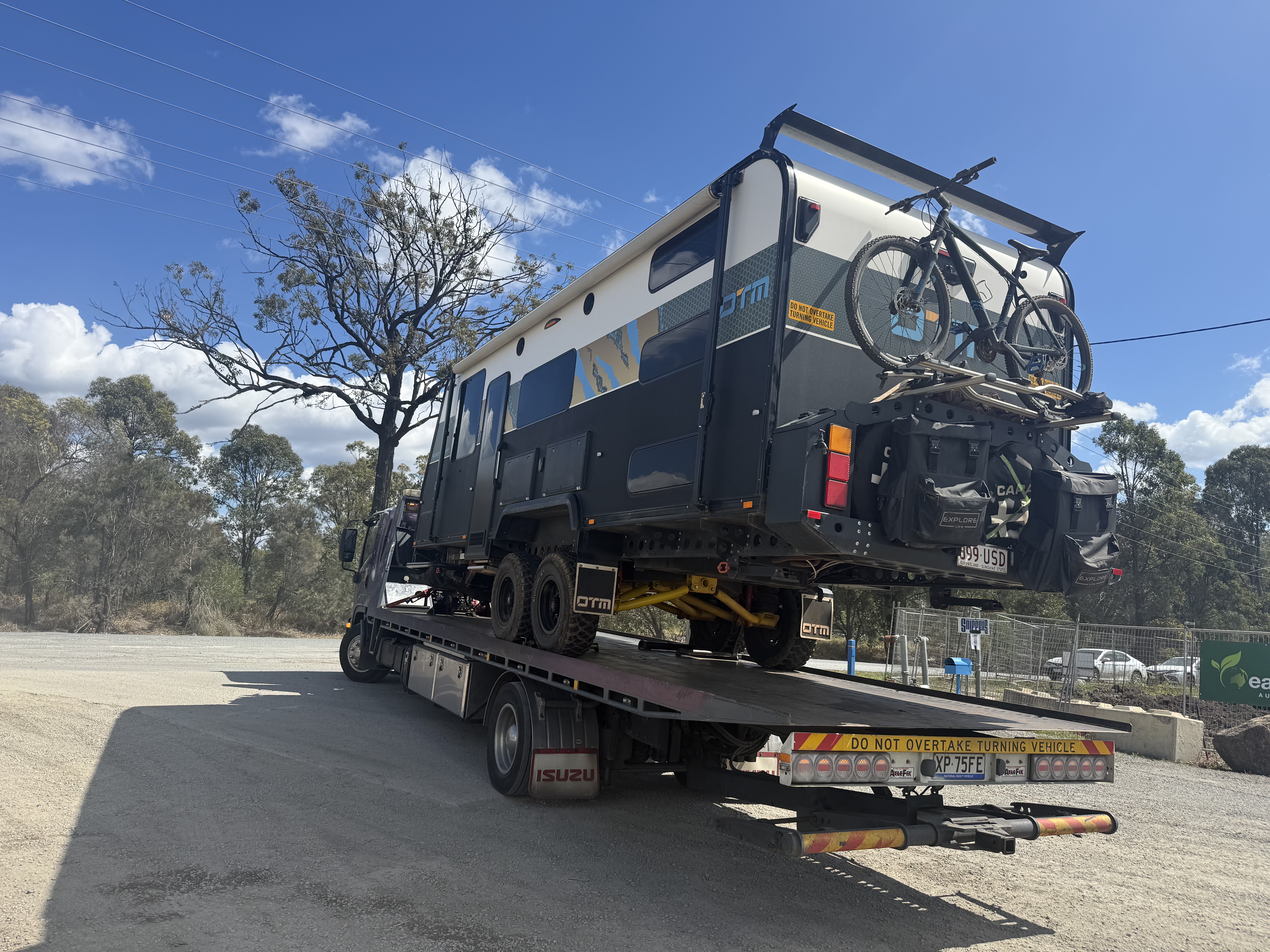 Off-road caravan loaded on flatbed tow truck