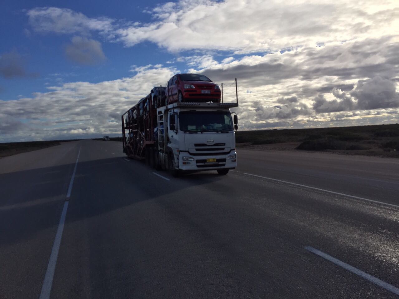 Auto Mover Red Sedan on Multi-Car Transport Carrier
