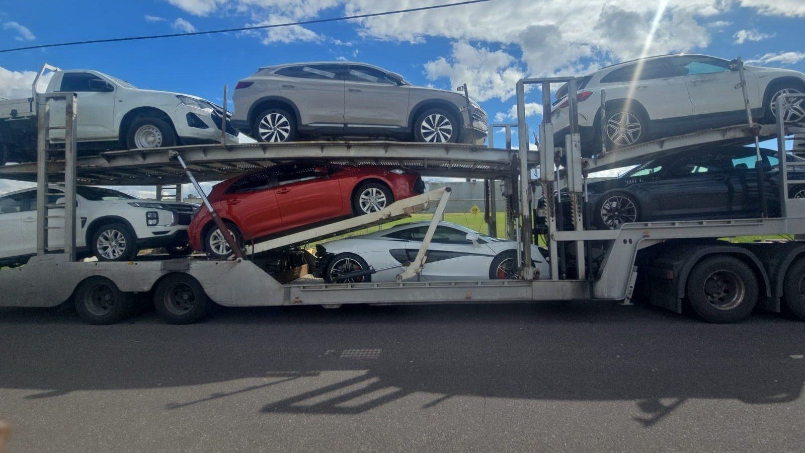 Auto Mover Red Sedan on Multi-Car Transport Carrier