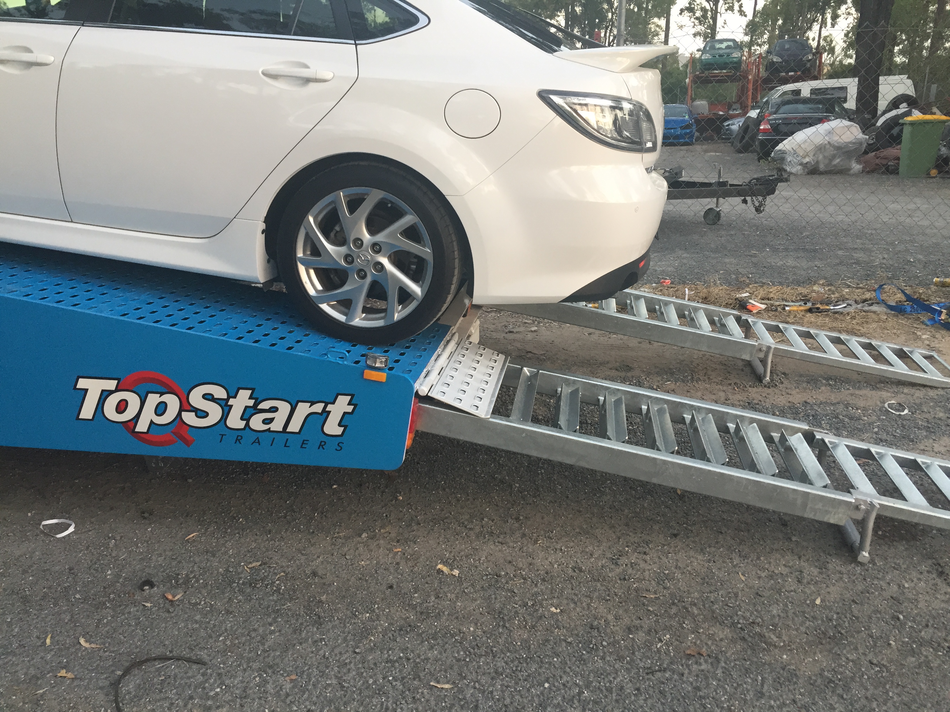 Auto Mover White Hatchback Secured on Car Carrier Trailer