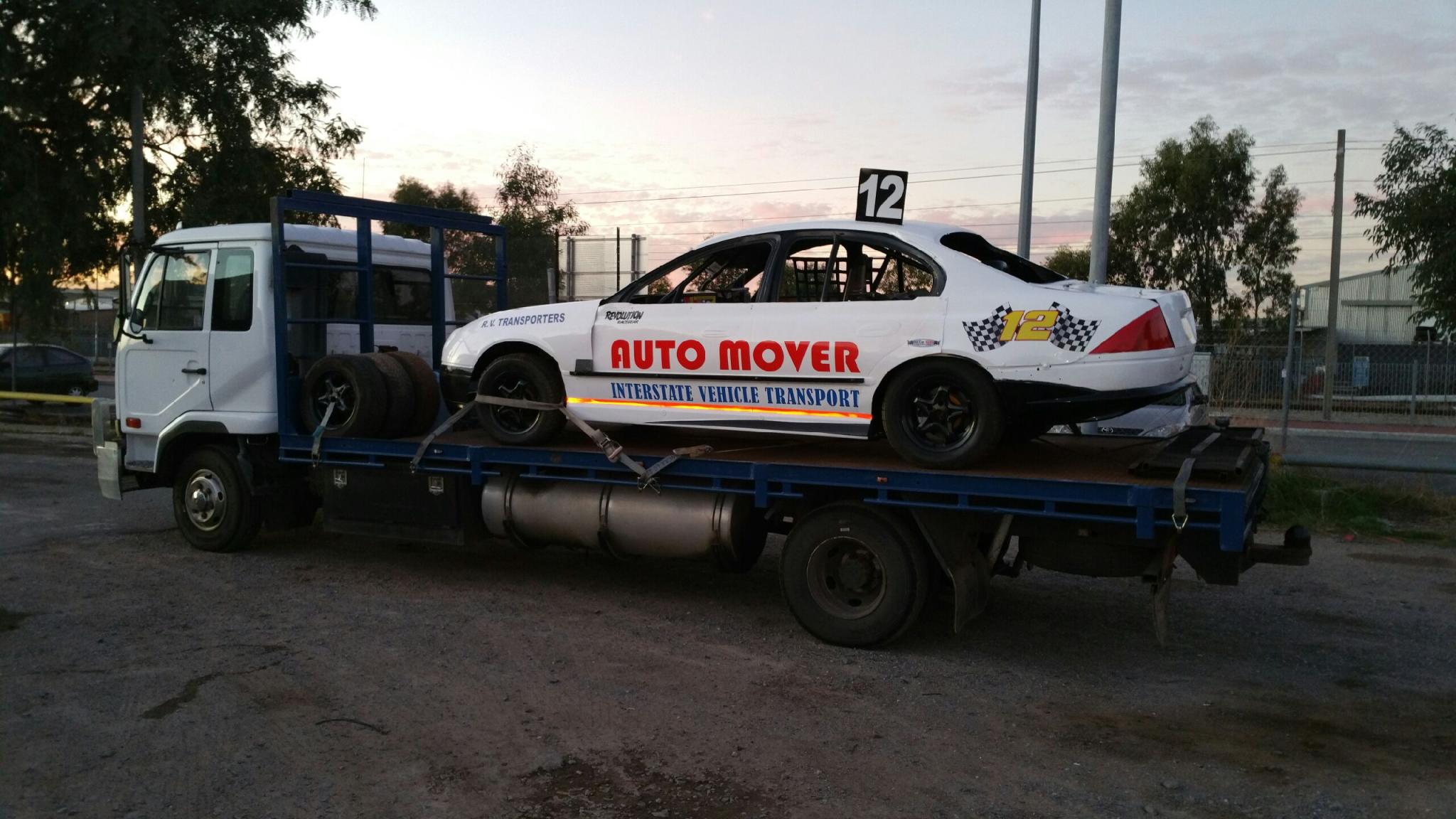 Auto Mover White Sedan on Interstate Transport Truck